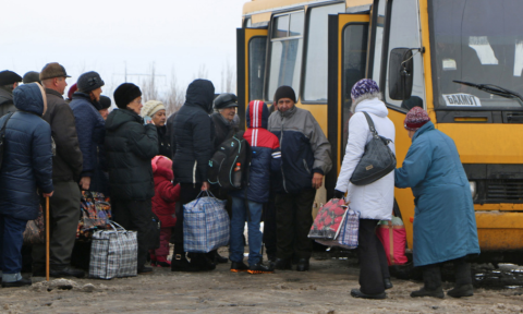 People travelling between government controlled to non-government controlled area of eastern Ukraine are loading onto a bus at the Mayorsk checkpoint