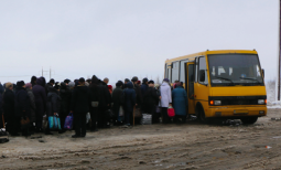 People loading onto a bus at the Mayorsk checkpoint to travel between the government controlled and non-government controlled areas of eastern Ukraine